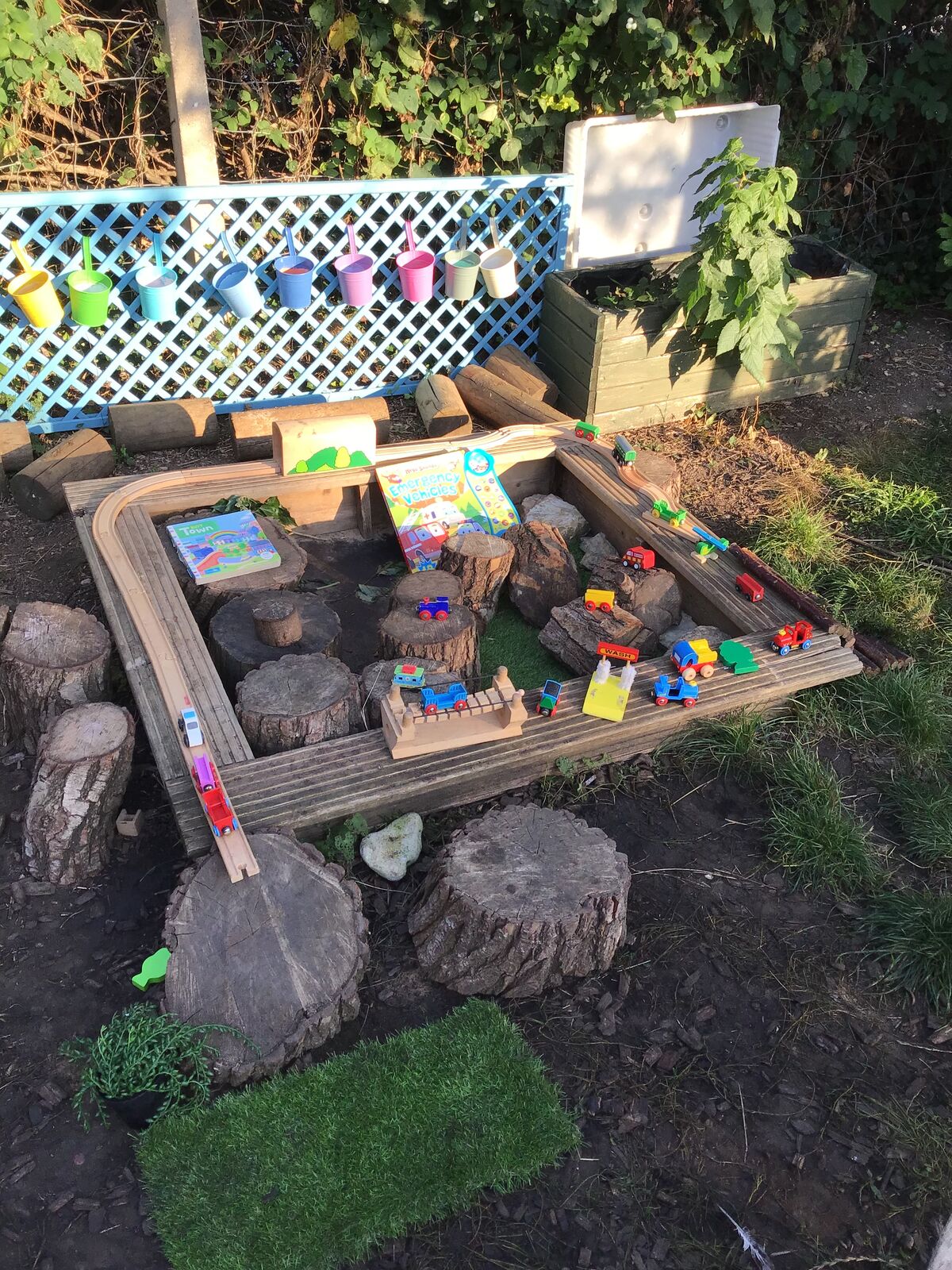 An outdoor small world area built with logs, stones and moss