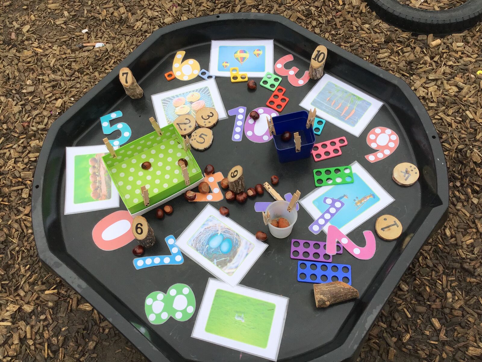 A tuff tray of number games, counters and wooden numerals
