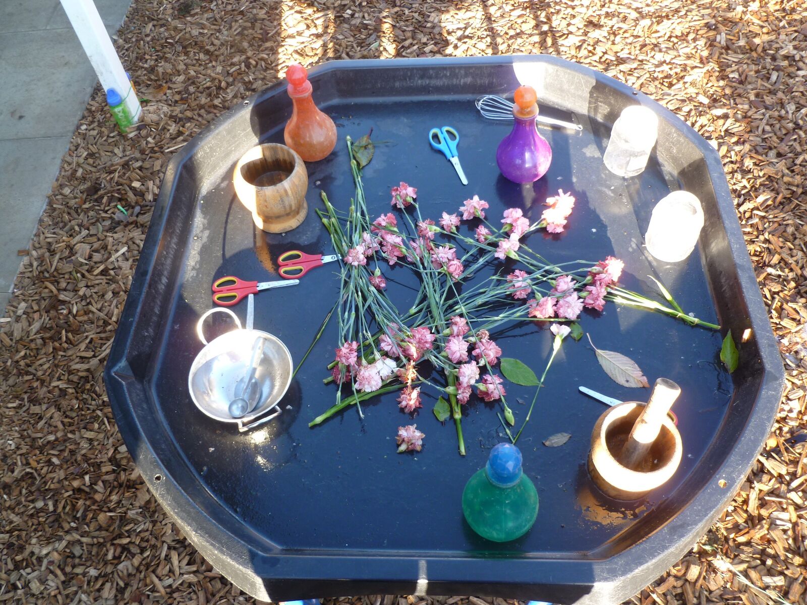 A potions tuff tray with blossom, jars, sieves and pestle and mortar
