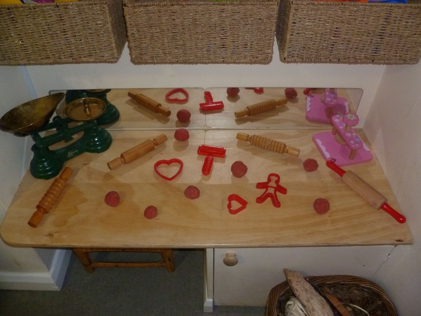 A dough table with rolling pins, cutters and coloured dough shapes